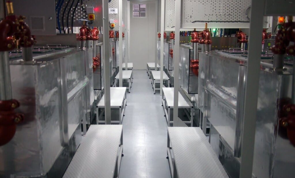 Servers submerged in non-conductive fluid reject heat in LiquidStack data tanks.