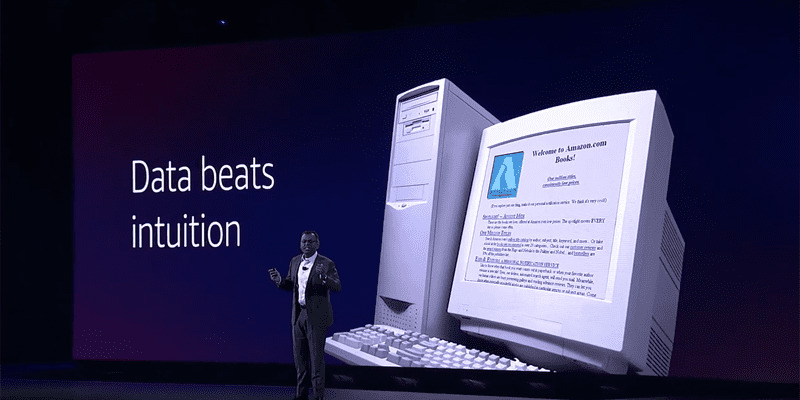 Swami Sivasubramanian delivers a keynote address at AWS re:Invent 2022 in front of a projector board that reads "data beats intuition."